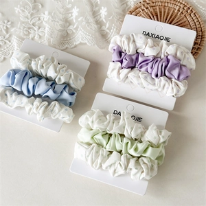 Detailed set of blue satin and polka dot scrunchies on elegant lace background