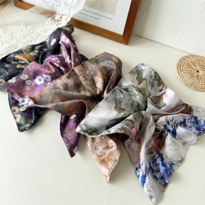 Flat lay of artistic satin square scarves featuring vintage van Gogh style ink patterns