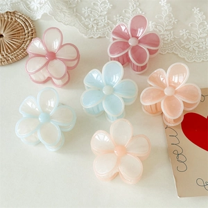 Gros plan sur des pinces à cheveux en forme de fleurs aux tons macaron et fini poli