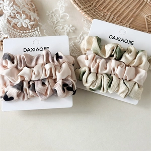 Set di tre elastici per capelli con motivi a cuore e floreali su eleganti cartoncini