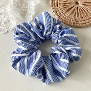 Détail du chouchou rayé bleu montrant la texture du tissu et les plis doux
