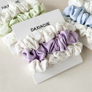 Detail of three-piece hair scrunchie sets with polka dots and solid colors in soft pastels