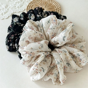 Close-up of floral chiffon scrunchies set in beige and black with vintage flower prints