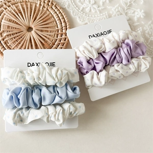 Close-up of three-piece scrunchie sets with polka dots and solid colors on display card