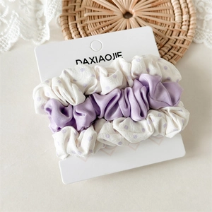 Detailed set of three elegant hair ties including purple satin and polka dot scrunchies