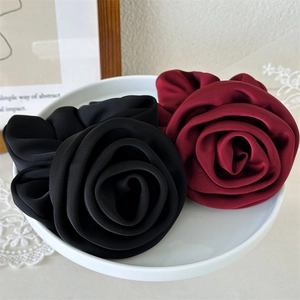 Close-up of elegant satin rose flower hair scrunchies in black and burgundy silk fabric