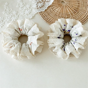 Close-up of set of 2 floral scrunchies with lace edges and vintage French aesthetic