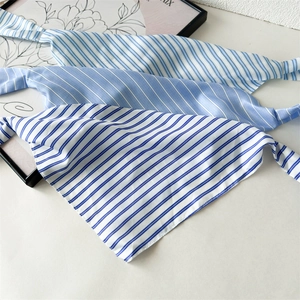 Detailed view of blue and white striped fabric scarves for hair with a soft glossy texture