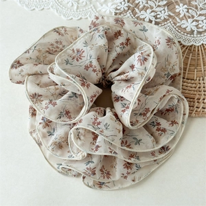 Detail of layered chiffon scrunchie with vintage floral print and pleated texture
