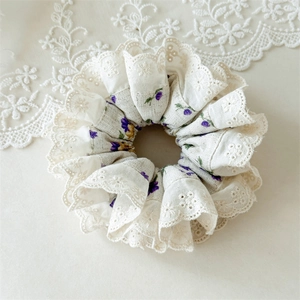 Detail of floral scrunchie with cream fabric, purple flowers and white lace trim