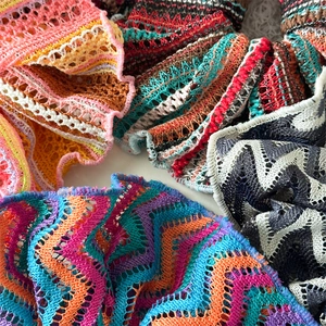 Detail of colorful hollow knit scrunchies showing intricate crochet textures and wavy edges