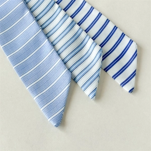 Detail of three blue and white striped fabric scarves showing silk-like satin texture