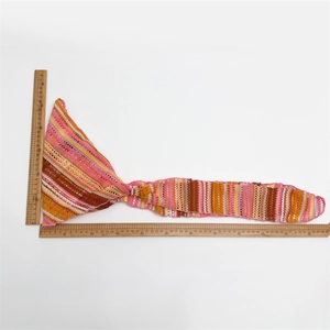 Detail showing measurement of multicolored striped knit headscarf with wooden rulers