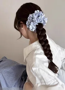 Detail eines hellblauen Satin-Haargummis mit floraler Spitze am Pferdeschwanz