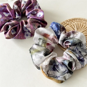 Close-up of vintage floral satin scrunchies with elegant ink painting patterns