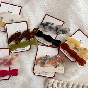 Detailed view of assorted acetate hair clips with marble patterns on display card