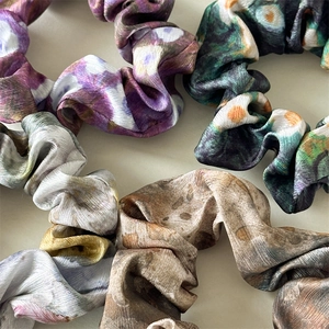 Detailed macro view of assorted satin scrunchies with ink painting patterns