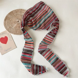 Detail showing the intricate crochet texture and colorful stripes of the knit headscarf
