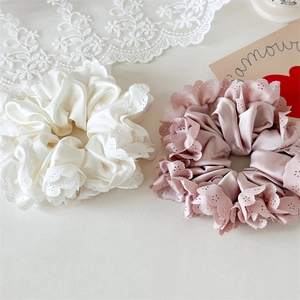 Detailansicht der weißen und rosa Satin-Haargummis mit feiner Blumen-Spitzenkante