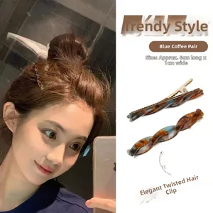 Detail view of blue and brown marble textured acetate hair clips with gold metal base