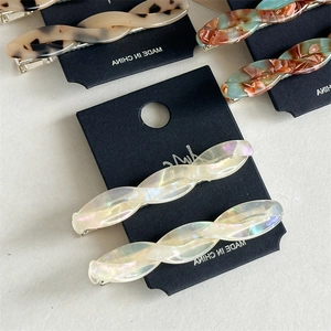 Detailed macro shot of acetate hair clips in assorted tortoiseshell and marble patterns