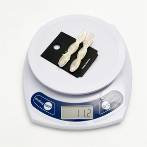 Pair of iridescent acetate twist hair clips on weight scale weighing 11.2 grams