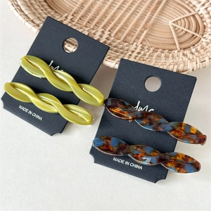 Detailed macro shot of vintage twist hair clips in olive green and tortoiseshell acetate