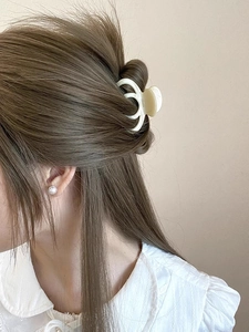 Detail of cream acetate hair claw clip holding hair securely with matte resin texture