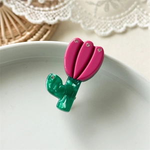 Makroaufnahme einer Tulpen-Haarklammer mit rosa Azetatblättern und funkelnden Strass