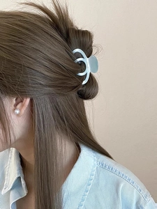 Detail view of light blue matte hair claw clip on model with elegant pearl earring