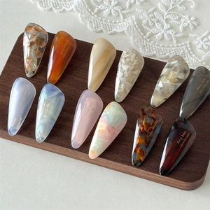 Close-up of acetic acid teardrop hair clips with marble and amber textures on wood