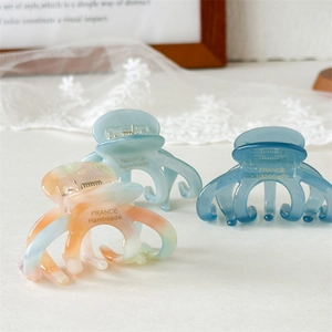 Detailed macro view of three acetate hair claws in blue and marble patterns