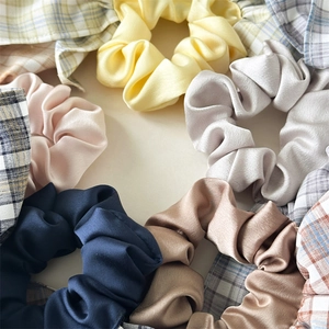 Detail von Vintage-Karo- und seidigen Satin-Haargummis in verschiedenen Farben für Frisuren