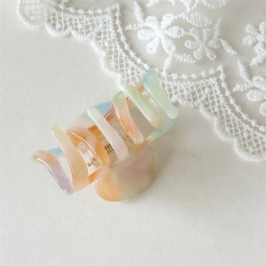 Detail view of large acetate pumpkin hair claw with marble macaron color gradient