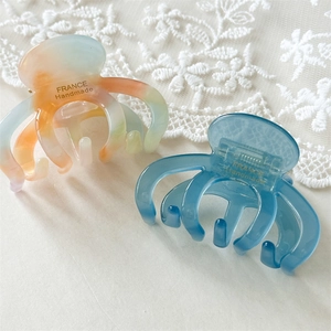 Handmade acetate octopus hair claws in marble and sea blue for a vintage hair styling