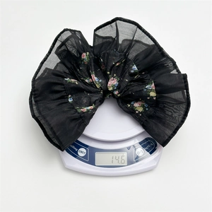 Detail shot showing the weight of a floral chiffon scrunchie at 14.6g on a digital scale