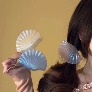 Détail de la pince à cheveux en forme de coquillage avec finition nacrée et ressort