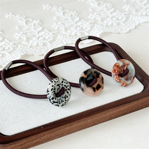 Lot de trois chouchous avec boutons en acétate aux motifs marbrés et floraux