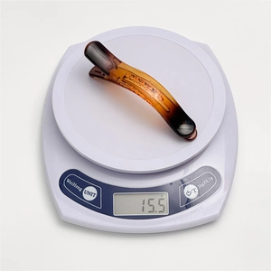 Detailed view of an amber resin hair clip on a scale weighing approximately 15.5g