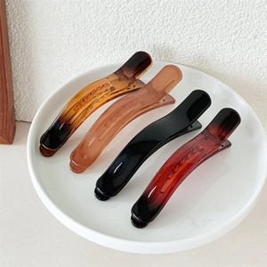 Set of four glossy jelly resin hair clips in amber, brown, and black for women
