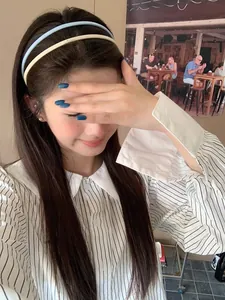 Detail of cream and light blue layered acrylic headbands on a model for casual styling