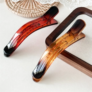 Detail view of smooth jelly texture and amber gradient hair clip with polished finish