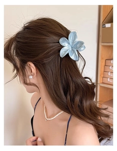 Pince à cheveux fleur avec texture marbrée bleue portée pour une coiffure élégante