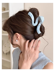 Détail d'une grande pince à cheveux à motif marbré bleu avec design ondulé
