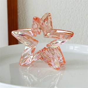 Close-up of laser hollow star hair claw with aurora iridescent finish on white dish