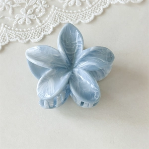 Détail d'une pince à cheveux fleur marbrée bleue avec dentelle blanche élégante