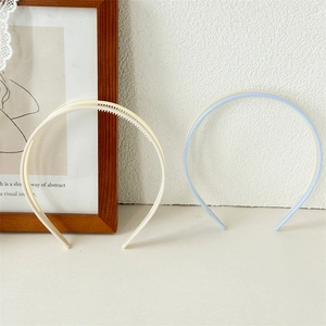 Close-up of cream and blue acrylic headbands showing the non-slip inner teeth detail