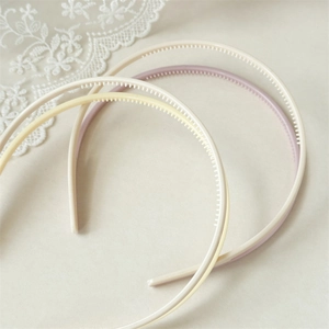 Detail showing anti-slip inner teeth of cream acrylic headbands in a three-piece set