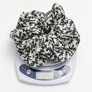 Detail view of large floral scrunchie on electronic scale showing weight of 24.6 grams