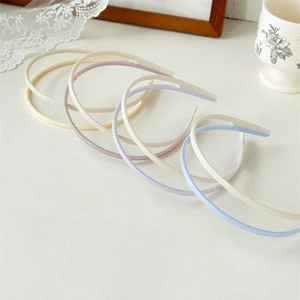 Close-up of pastel acrylic headbands with non-slip inner teeth in cream macaron colors